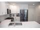 Modern kitchen with white cabinets, stainless steel appliances, and quartz countertops at 9841 E 56Th Pl, Denver, CO 80238