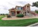 Two-story home with red exterior, landscaping, and walkway at 13722 Legend Way # 101, Broomfield, CO 80023