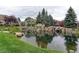 Community pond with landscaping and a sign at 13722 Legend Way # 101, Broomfield, CO 80023