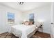 Well-lit bedroom with two large windows, hardwood floors, and neutral decor at 203 W Rafferty Gardens Ave, Littleton, CO 80120