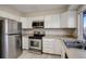 Stainless steel appliances and white cabinets in this kitchen at 7877 York St # 1, Denver, CO 80229