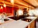 Modern kitchen featuring red cabinets and a spacious island at 13640 Old Paint Trl, Conifer, CO 80433