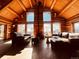 Spacious living room with large windows, wood beams, and leather sofas at 13640 Old Paint Trl, Conifer, CO 80433