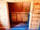 Small log cabin closet with wood shelving and floor at 13640 Old Paint Trl, Conifer, CO 80433