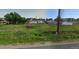 Vacant lot with overgrown grass, a rusty tractor, and neighboring houses in the background at 13305 W 82Nd Ave, Arvada, CO 80005