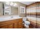 Bathroom with wood vanity, shower/tub combo, and window at 28532 Shadow Mountain Dr, Conifer, CO 80433
