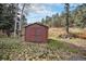 Red storage shed in backyard with double doors at 28532 Shadow Mountain Dr, Conifer, CO 80433