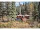 House nestled in a wooded area with a shed at 28532 Shadow Mountain Dr, Conifer, CO 80433