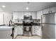 Modern kitchen with stainless steel appliances and white cabinets at 100 Park Ave # 204, Denver, CO 80205