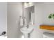 Clean and modern bathroom with pedestal sink and wood shelf at 1435 W 68Th Ave, Denver, CO 80221