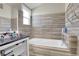 Updated bathroom with a soaking tub, dark tile walls, and a window for natural light at 4453 S Fundy St, Centennial, CO 80015