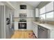 Kitchen with stainless steel appliances, white cabinets, granite countertops, and wood floors at 4453 S Fundy St, Centennial, CO 80015