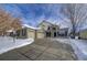 Two-story brick home with three-car garage and snowy front yard at 1390 Peninsula Cir, Castle Rock, CO 80104