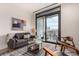 Living room with city view, balcony access, and mid-century modern furniture at 1901 Wazee St # 719, Denver, CO 80202
