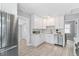 White kitchen with stainless steel appliances and tiled floor at 4424 Decatur St, Denver, CO 80211