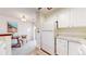 White kitchen with appliances and an adjacent dining area at 8116 Gray Ct # 482, Arvada, CO 80003