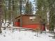 Rustic log cabin nestled in snowy woods, offering a secluded feel at 5525 S Twin Spruce Dr, Evergreen, CO 80439