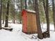 Wooden shed with red door in snowy woods at 5525 S Twin Spruce Dr, Evergreen, CO 80439