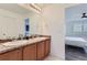 Main bathroom with double sinks and view of bedroom at 6645 Dry Fork Dr, Frederick, CO 80516