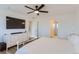 Primary bedroom with large TV, dresser, and ensuite bath at 6645 Dry Fork Dr, Frederick, CO 80516