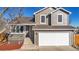 Two-story house with gray siding, a white garage door, and a deck at 1755 E 96Th Way, Thornton, CO 80229