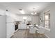 Virtually staged kitchen with white cabinets and dining area at 1670 S Deframe St # C1, Lakewood, CO 80228