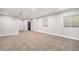 Open basement space with carpet flooring, white walls, and multiple windows at 7285 S Titus Way, Aurora, CO 80016