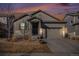 Inviting home exterior at dusk with warm lighting and a cozy atmosphere at 7285 S Titus Way, Aurora, CO 80016
