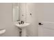 Modern bathroom with pedestal sink, black fixtures, and a large mirror at 11575 Toccata Trl, Parker, CO 80134
