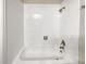 Bathroom with white tiled walls and a white bathtub at 4507 S Lowell Blvd, Denver, CO 80236