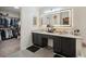 Double vanity bathroom with a walk-in closet and large mirror at 5926 W Long Dr, Littleton, CO 80123