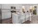 Modern kitchen with island, stainless steel appliances, and white cabinetry at 15881 Willow Way, Thornton, CO 80602