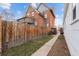 Brick home with a long backyard, wooden fence, and walkway at 2229 S Bannock St, Denver, CO 80223