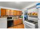 Kitchen with wood cabinets, gas range, and dishwasher at 2229 S Bannock St, Denver, CO 80223