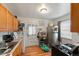 Kitchen features wood cabinets, gas range, and a view into the adjacent laundry area at 2229 S Bannock St, Denver, CO 80223