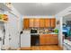 Kitchen with wood cabinets, gas range, and a view to the living room at 2229 S Bannock St, Denver, CO 80223