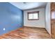 Bedroom with hardwood floors, a window, and blue accent wall at 8631 Faraday St, Denver, CO 80229