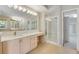 Bathroom with light cabinets, a large mirror, and a shower at 22141 Chippewa Ln, Golden, CO 80401