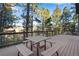Deck with table and benches, overlooking wooded area at 22141 Chippewa Ln, Golden, CO 80401
