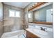 Clean bathroom with tan tile and wood vanity at 3265 Mather St, Brighton, CO 80601