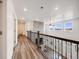 Upstairs hallway with hardwood floors and railing at 16475 Essex S Rd, Platteville, CO 80651