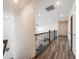 Upstairs hallway with hardwood floors and railing at 16475 Essex S Rd, Platteville, CO 80651