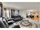 Open-concept living room with leather furniture and a view of the dining area and kitchen at 1214 S Akron Way, Denver, CO 80247