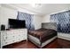 Bright bedroom with a comfortable bed, dresser, and large TV at 1654 S Perry St, Denver, CO 80219