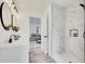 Elegant bathroom featuring a walk-in shower with marble tile and a view into the living room at 14405 County Road 12, Fort Lupton, CO 80621