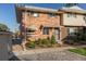 Brick townhouse with landscaping and walkway at 9131 E Mansfield Ave, Denver, CO 80237