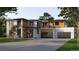 Two-story modern home with wood and white exterior, three-car garage, and landscaped lawn at 5266 Flora Way, Arvada, CO 80004