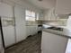 Simple kitchen with white cabinets, laminate countertops, and built-in appliances at 8055 E Bethany Pl, Denver, CO 80231