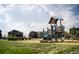 Modern playground with playset and slide, set in a grassy area at 8596 Hotchkiss St, Littleton, CO 80125