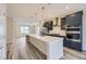 Modern kitchen with large island, stainless steel appliances, and dark cabinets at 8363 Mount Kataka St, Littleton, CO 80125